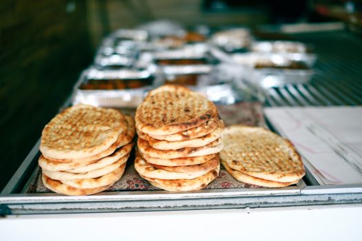 A variety of freshly baked flatbreads displayed on a market table, ready for purchase.