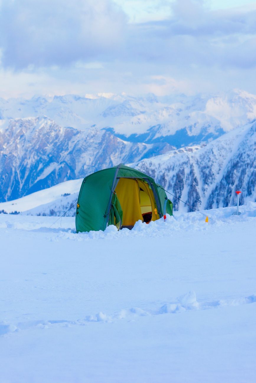 Green tent pitched on snow, the sort of setup that only works when the sleeping bag, layers and pad are working as one system