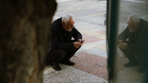 An older man is looking at his cell phone