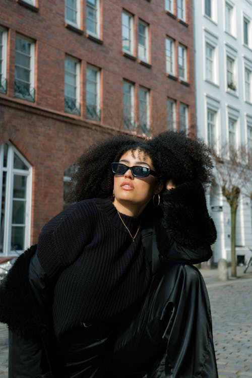 Woman Wearing Black Jacket in Front of Tenements