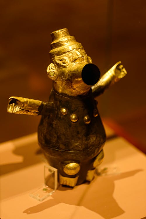 A gold statue of a man with a hat on display