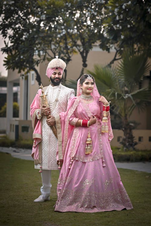 A couple in pink wedding attire posing for a photo