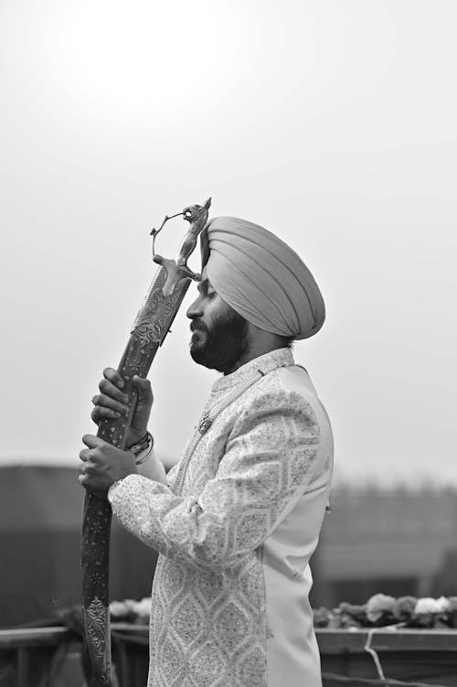 A man in a turban holding a long stick