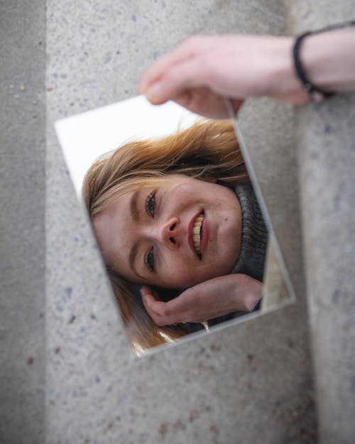 Free Reflection of Happy Blonde Woman on Mirror in Hand Stock Photo