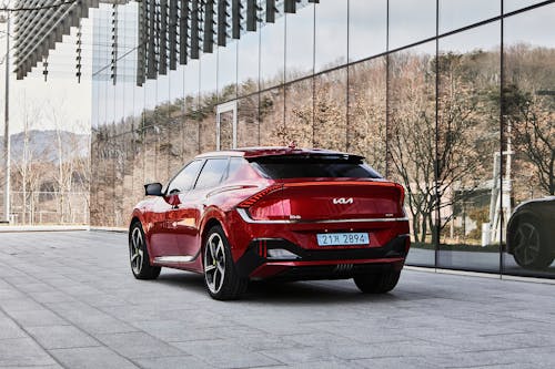 The left rear side of the Kia EV6 GT parked in front of a building.