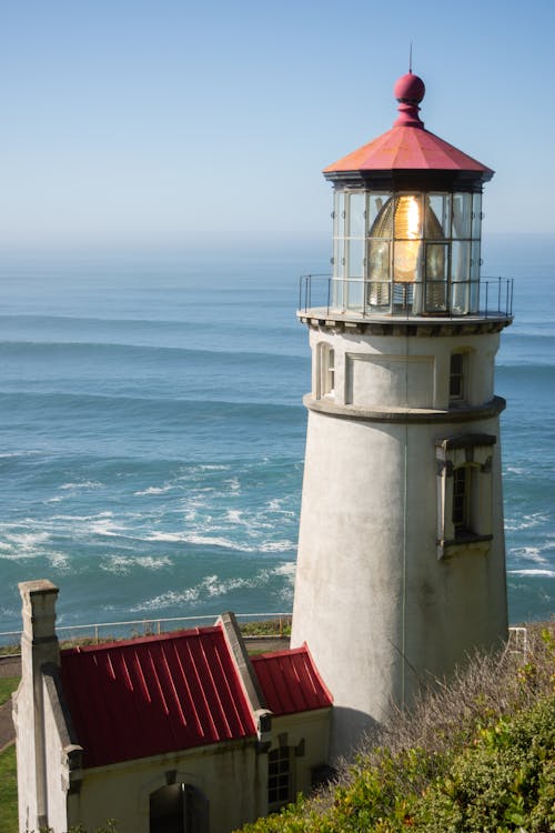 A lighthouse is on a cliff overlooking the ocean