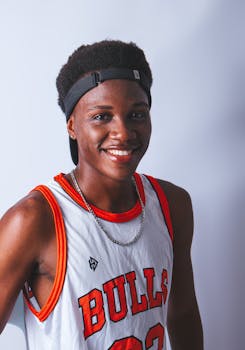 Portrait of a smiling teenager wearing a Bulls basketball jersey and headband.