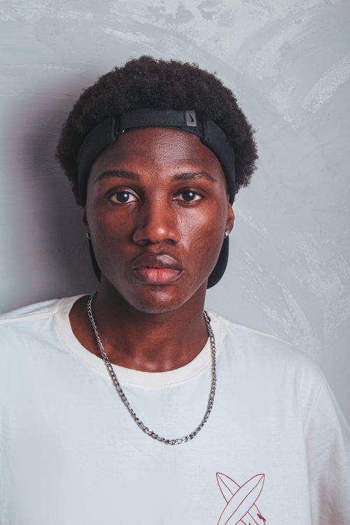 Free Stylish portrait of a young black man in a studio setting with a white background. Stock Photo