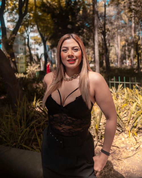 Free Elegant woman in black dress enjoying a sunny day in a park, capturing modern fashion vibes. Stock Photo
