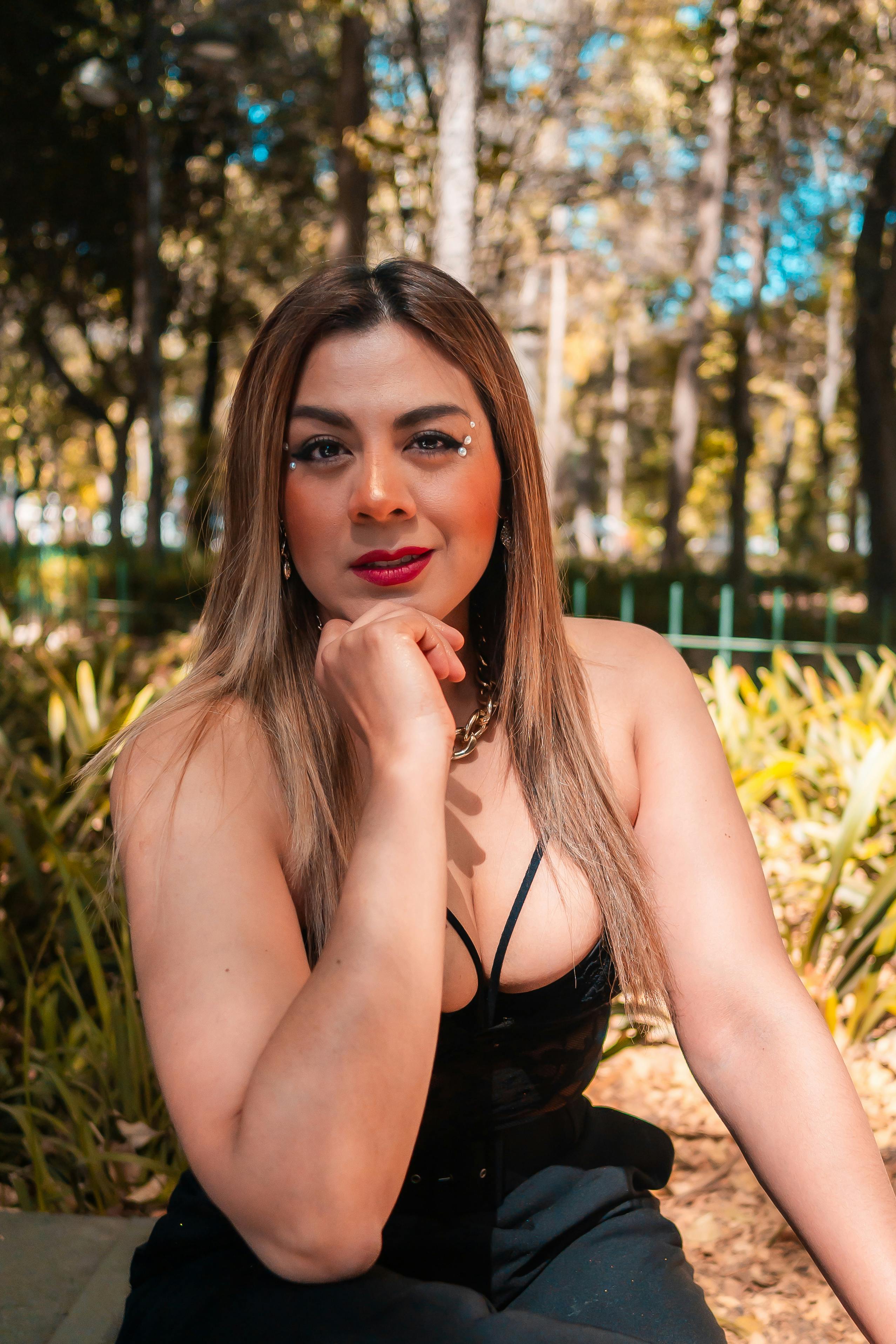 Portrait of a fashionable woman relaxing outdoors in a sunlit city park.