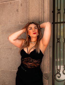 Stylish portrait of a woman posing gracefully against a stone wall, exuding confidence and elegance.