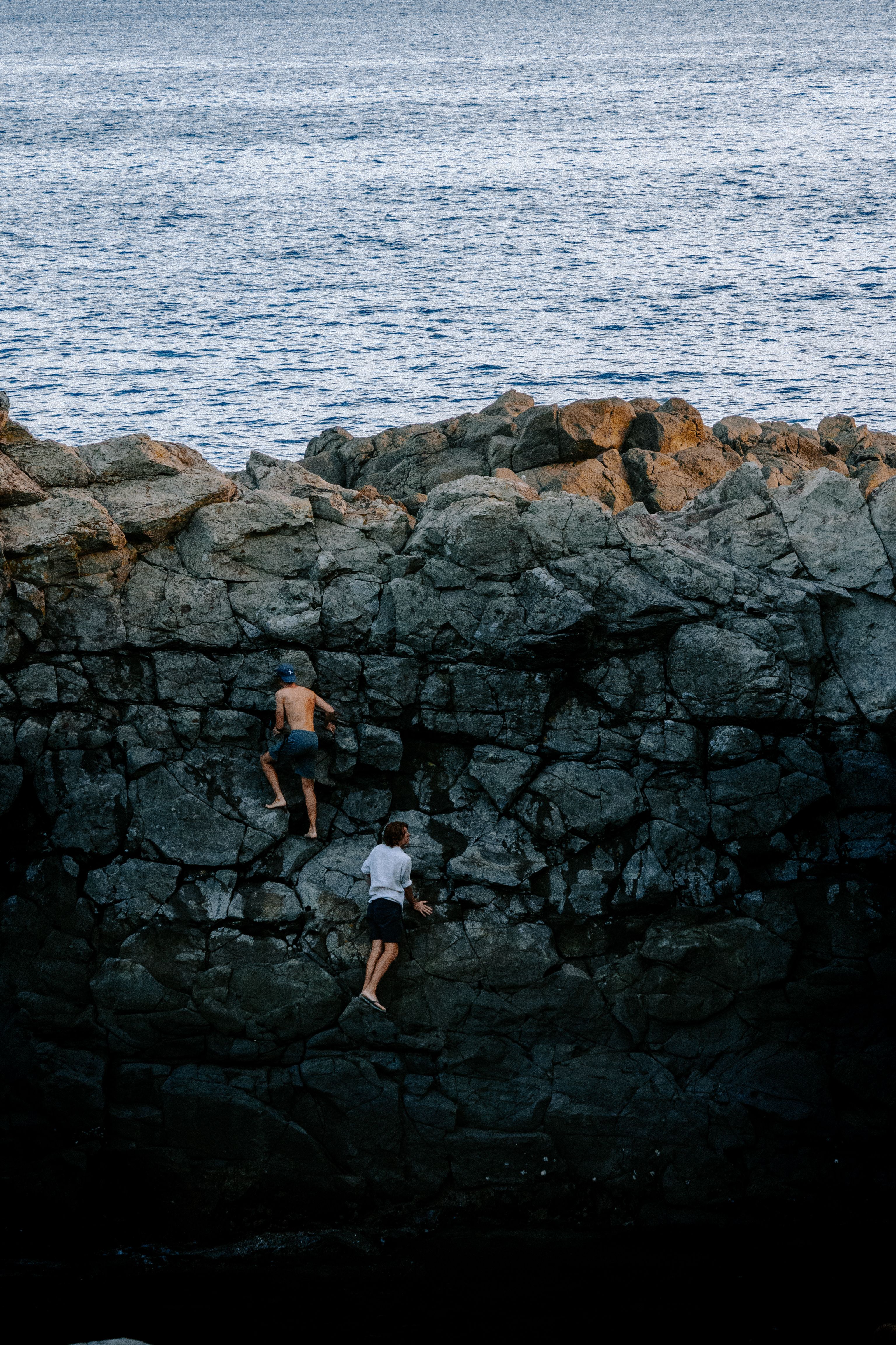 People Climbing Rocks at the Seashore · Free Stock Photo