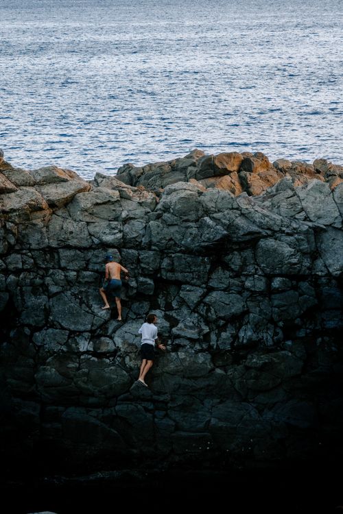 People Exploring Rocks People Climbing Rocks at the Seashore · Free Stock Photo