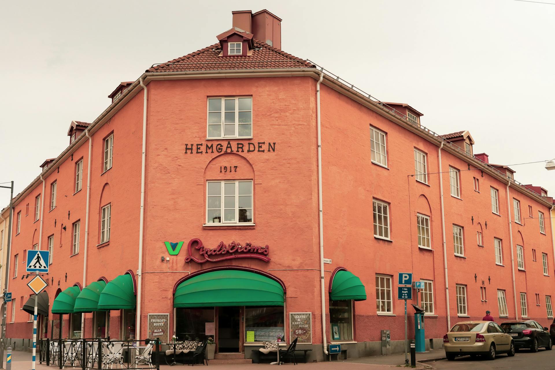 Orange historic building with green canopies on a city street in Jönköping, Sweden.
