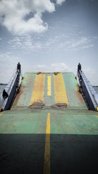 A green ramp of a landing craft with a yellow arrow directs vessels.
