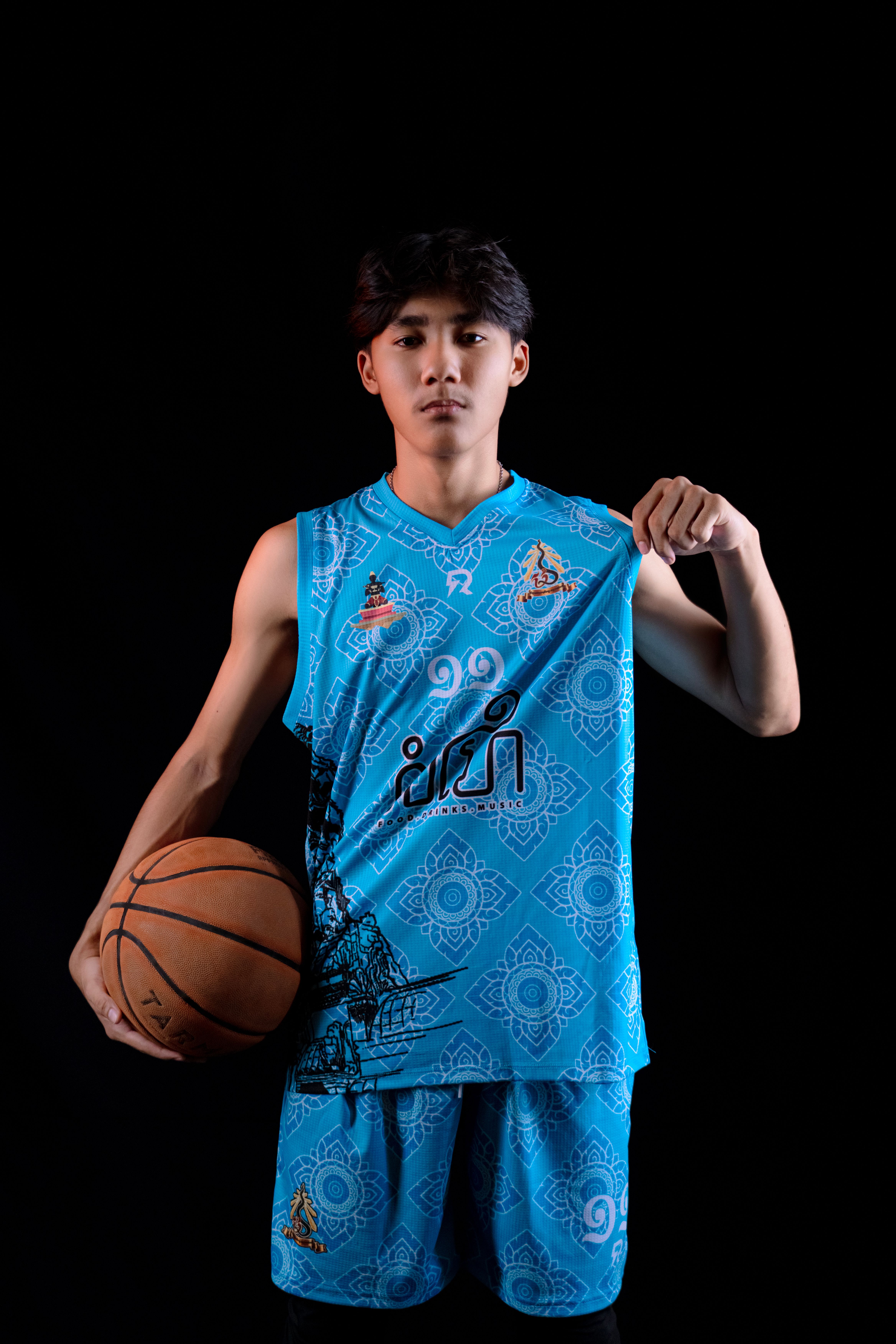Teen basketball player in striking blue sportswear posing confidently with a basketball.