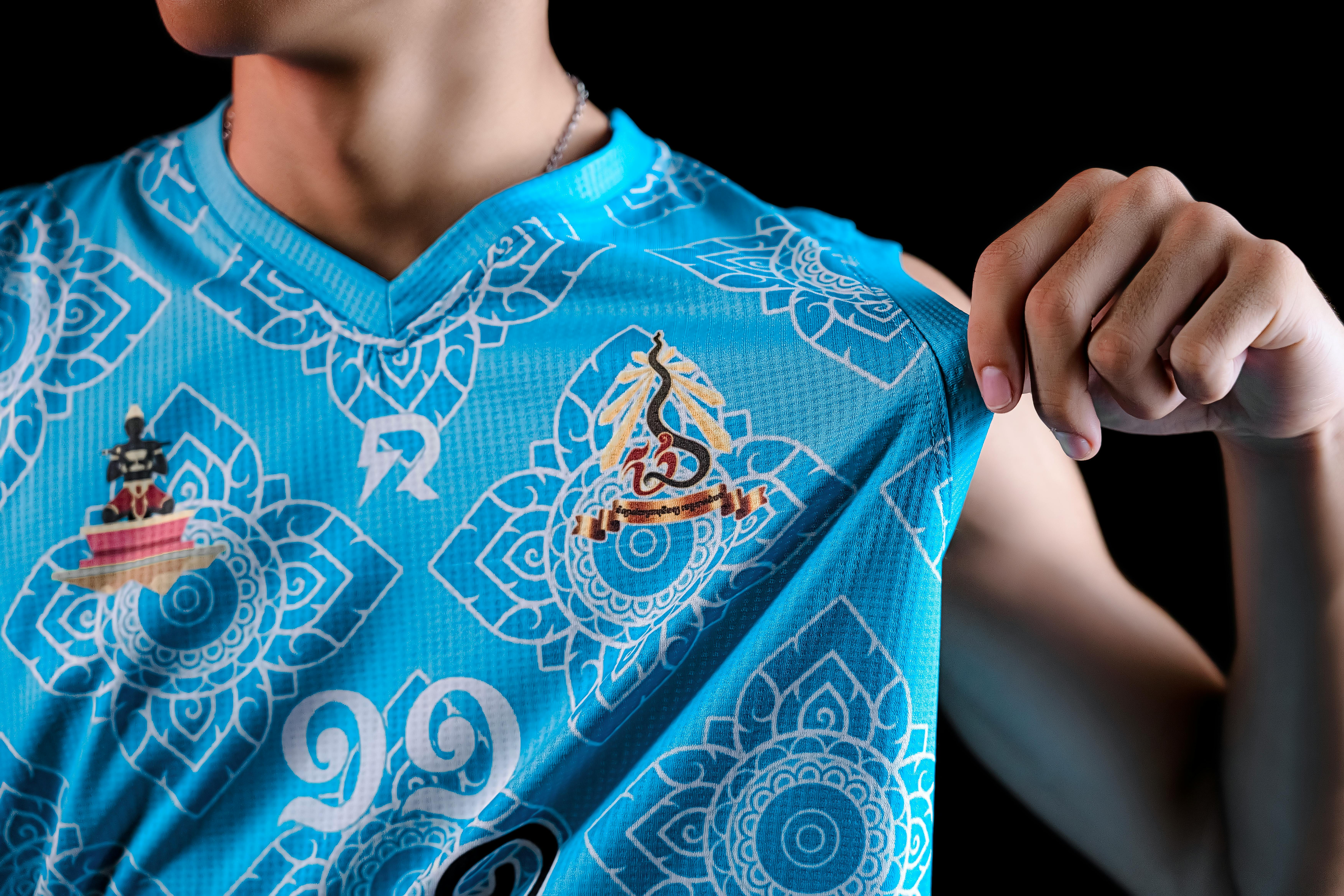 Detailed view of a vibrant blue sports jersey featuring intricate patterns and logos.