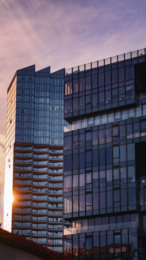 Free Striking urban landscape with modern glass office buildings during a vibrant sunset. Stock Photo