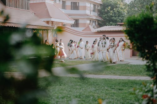 A wedding party walking through a garden