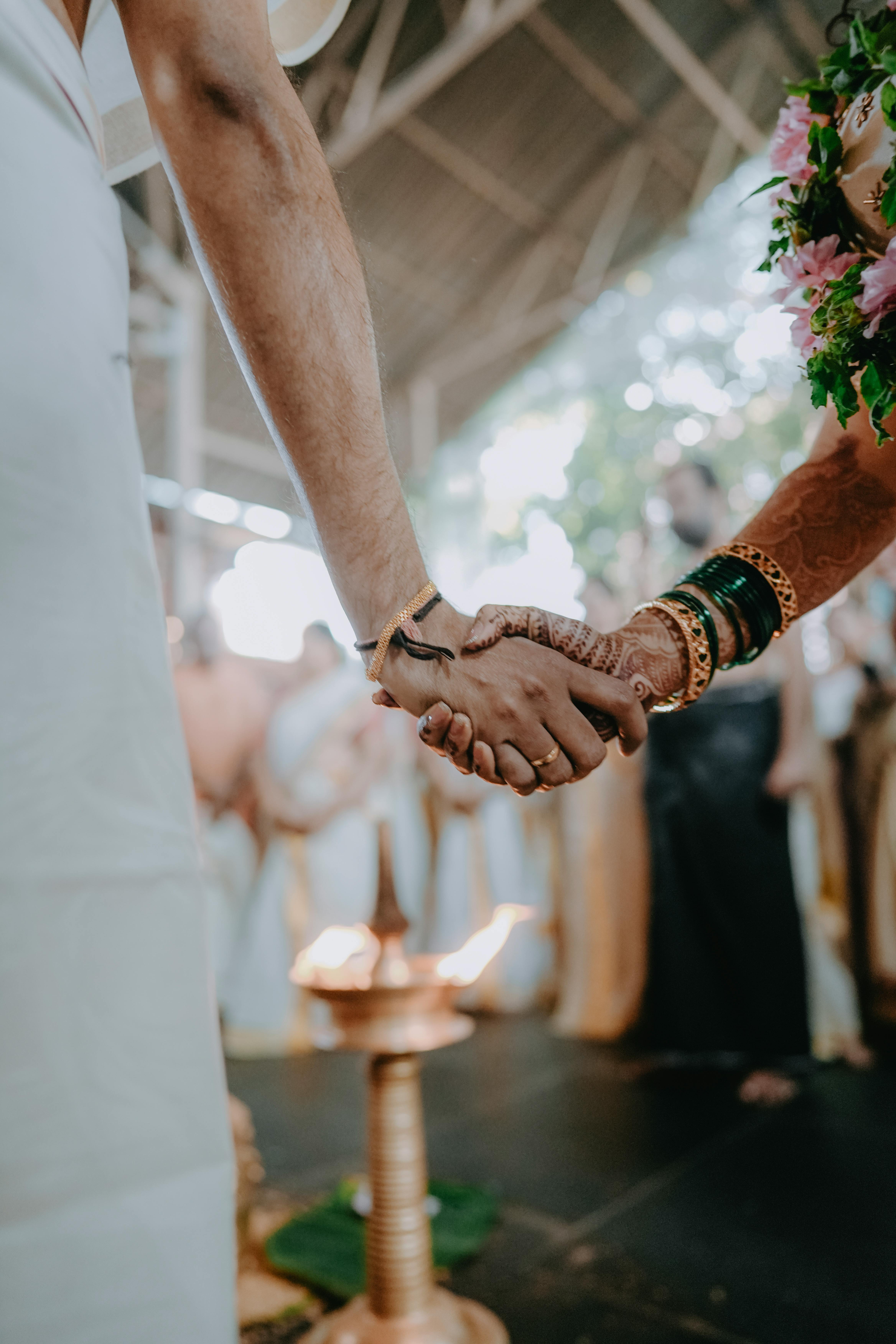 https://images.pexels.com/photos/20616440/pexels-photo-20616440/free-photo-of-a-couple-holding-hands-at-their-wedding-ceremony.jpeg?auto=compress&cs=tinysrgb&w=1260&h=750&dpr=1