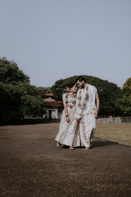 A couple in traditional indian attire walking down a path