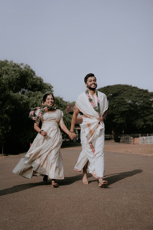 A bride and groom walking down the street in traditional attire