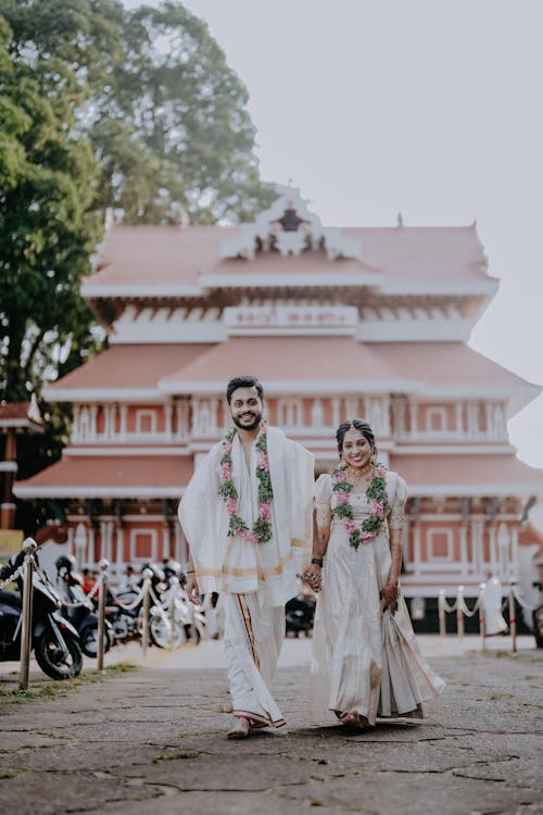A couple walking down the street in front of a temple