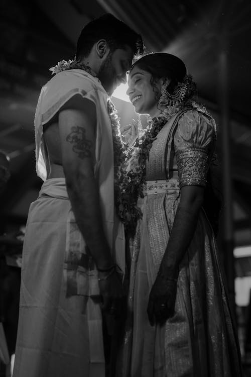 A black and white photo of a couple in traditional attire