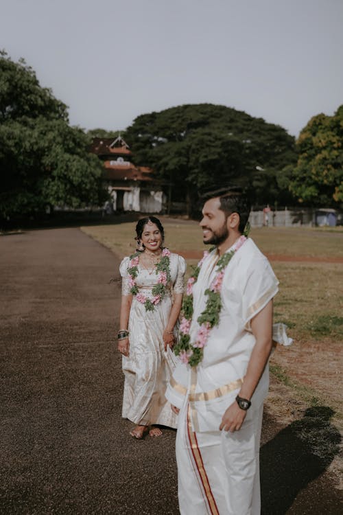 A man and woman in traditional attire walking down a path