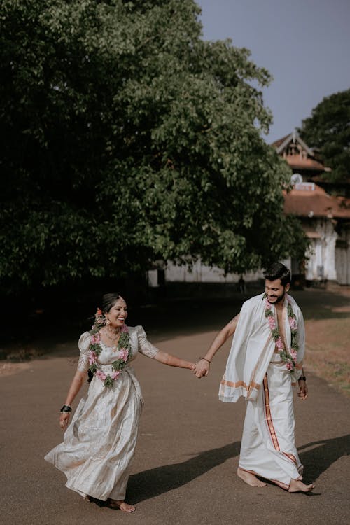 A couple in traditional attire walking down a path