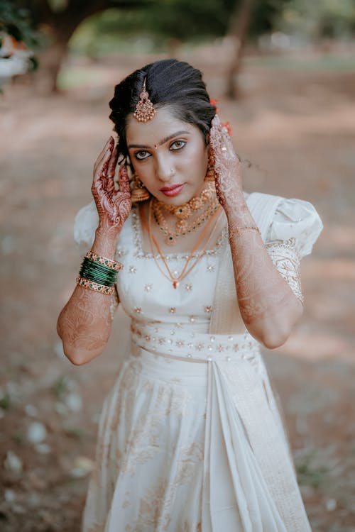 A beautiful indian bride in white dress and gold jewelry