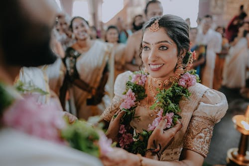 A bride in traditional indian garb smiling at her groom