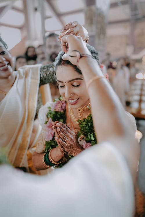 A bride putting on her wedding jewelry