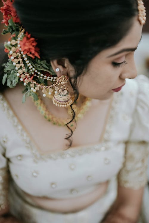 A bride in traditional indian attire with gold jewelry
