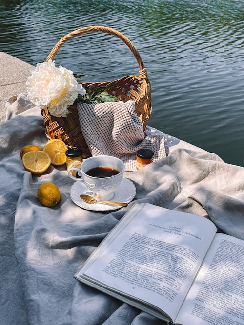 Book, Tea and Flowers on Picnic by River