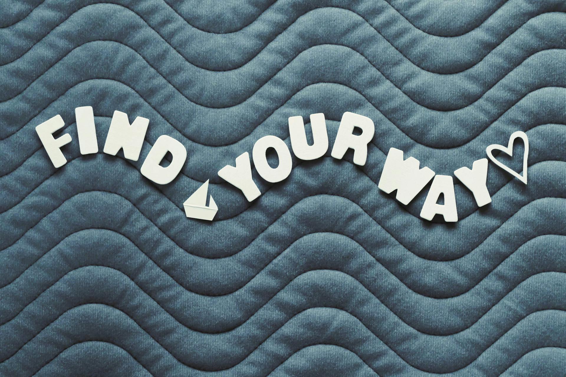 Motivational quote 'Find Your Way' on wave pattern background with heart icon.