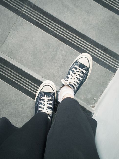 A top view of stylish sneakers standing on urban concrete stairs.