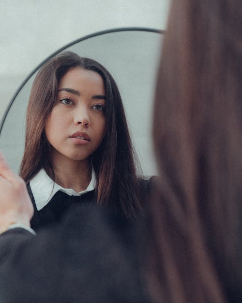 Woman in Sweater with White Collar Looking at Mirror