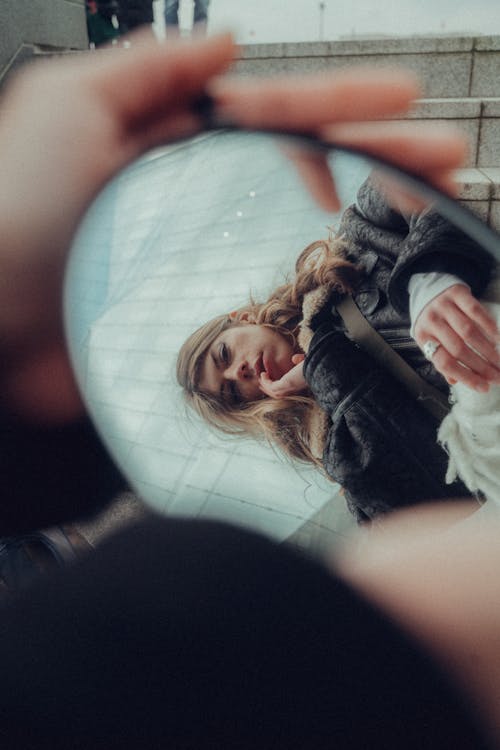 A woman is looking at herself in a mirror