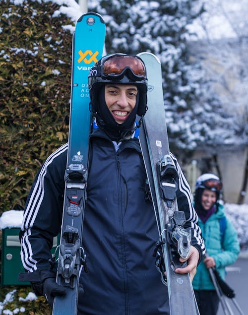 A man holding two skis in his hands