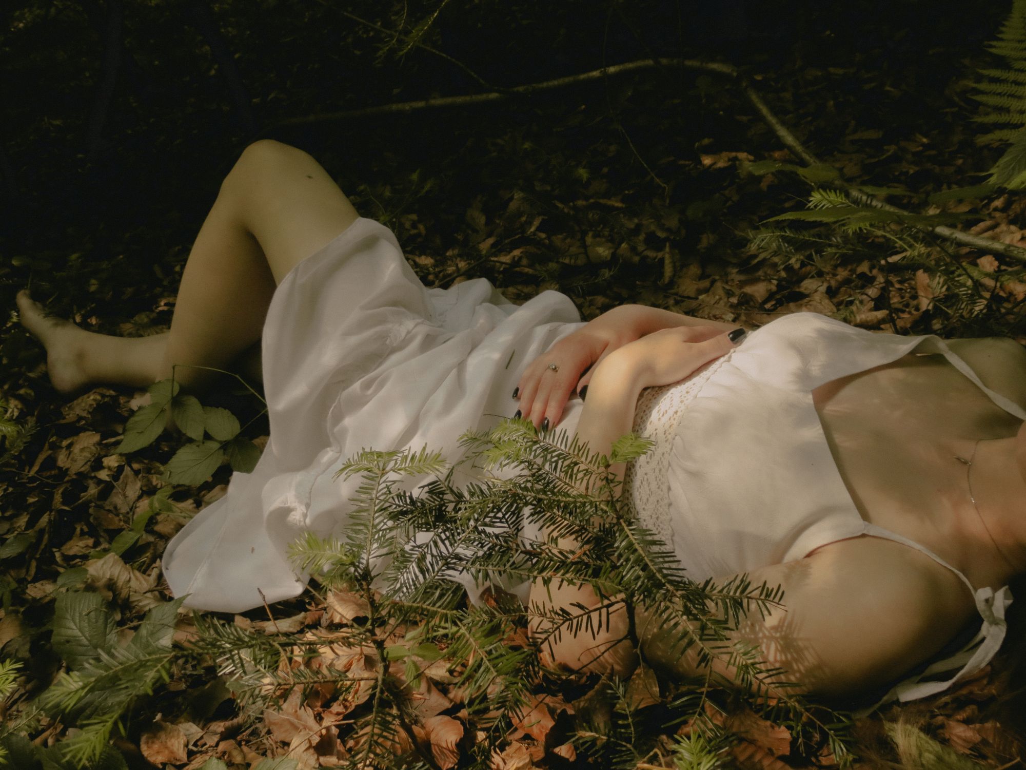 Woman in a White Dress Lying on the Forest Floor · Free Stock Photo