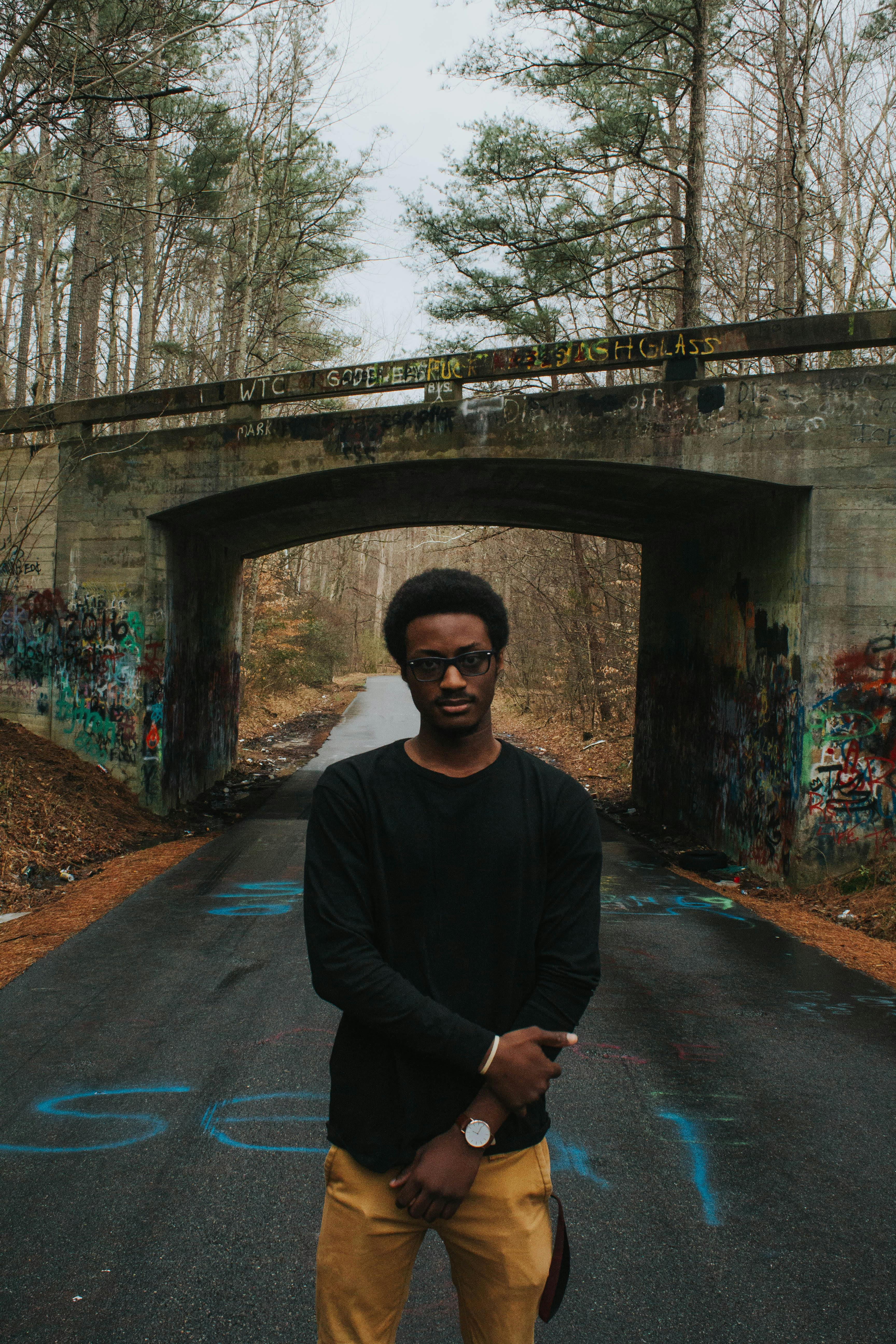 Man Standing on Asphalt Road Beside Bridge · Free Stock Photo