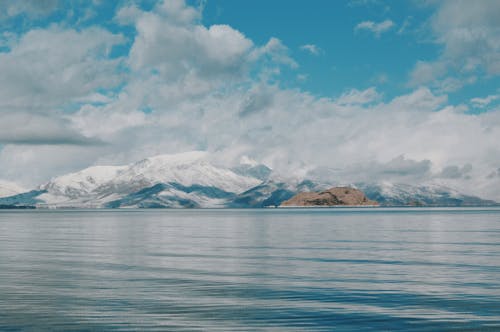 A body of water with snow capped mountains in the background