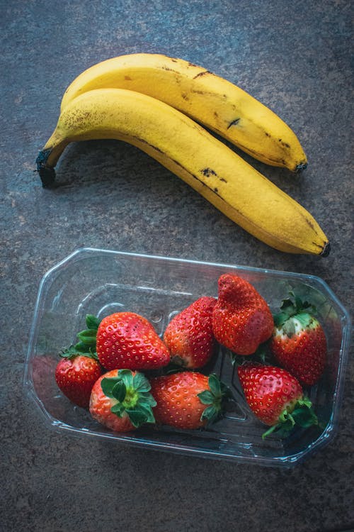 Bananas and strawberries in a plastic container