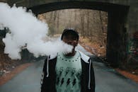 一名年轻人在城市的地下通道里吸着烟，周围是大自然和涂鸦