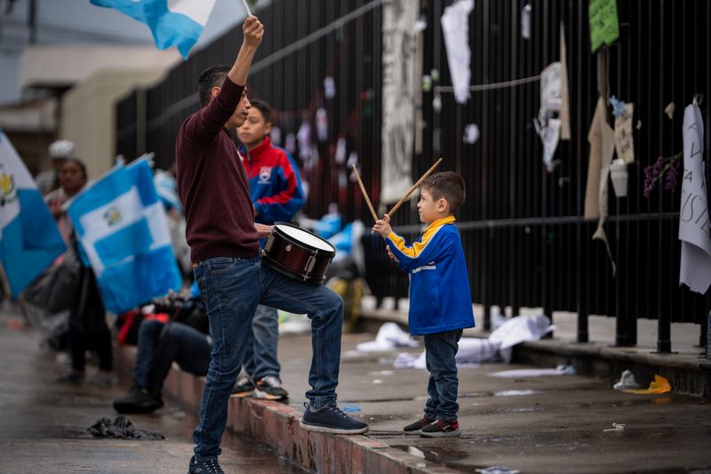Family celebrating with drum and Guatemala flags on the street