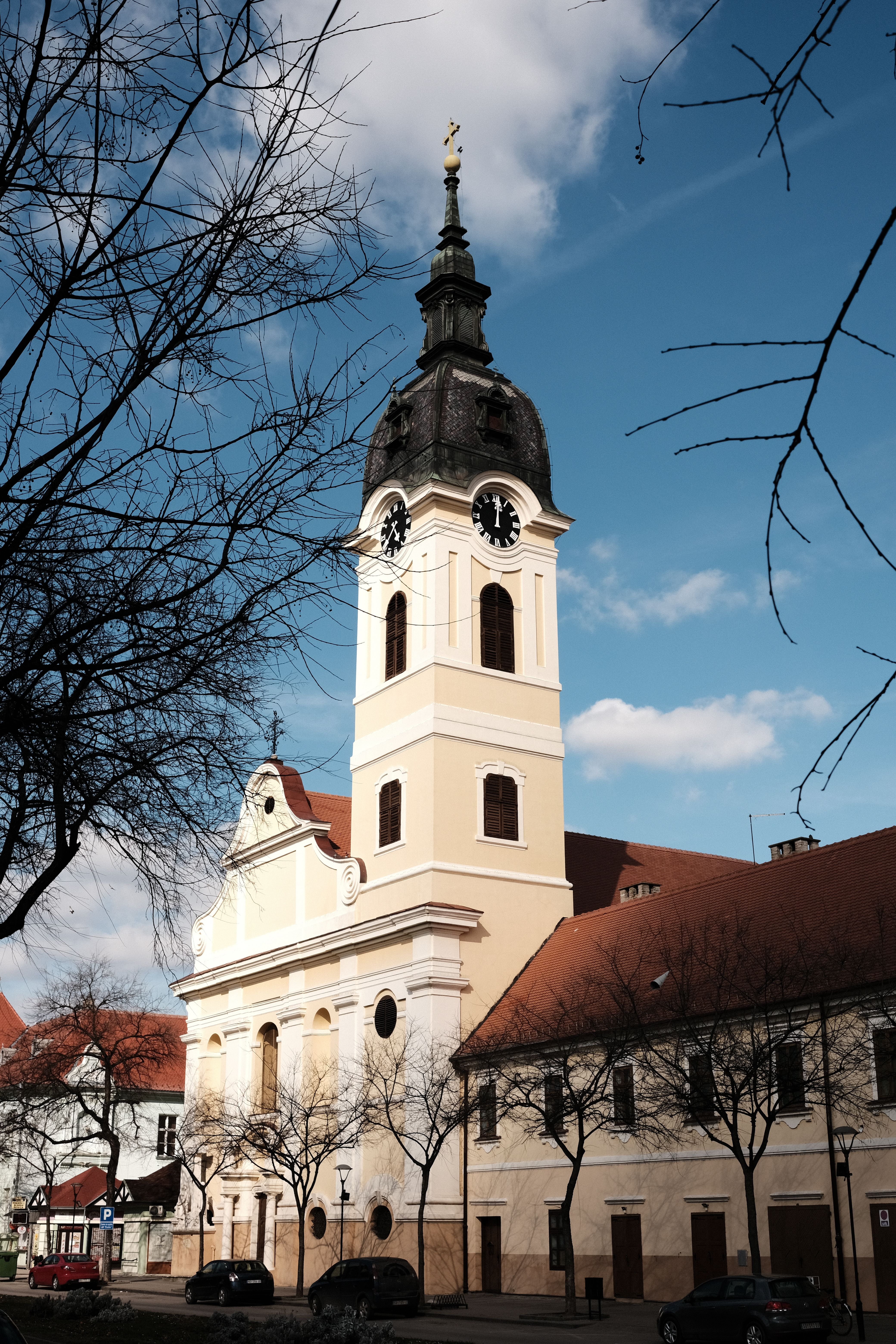 Scenic view of a Roman Catholic church tower in Sombor, Serbia against a blue sky.