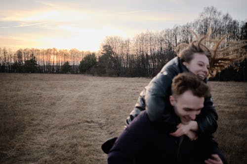 A man carrying a woman in a field