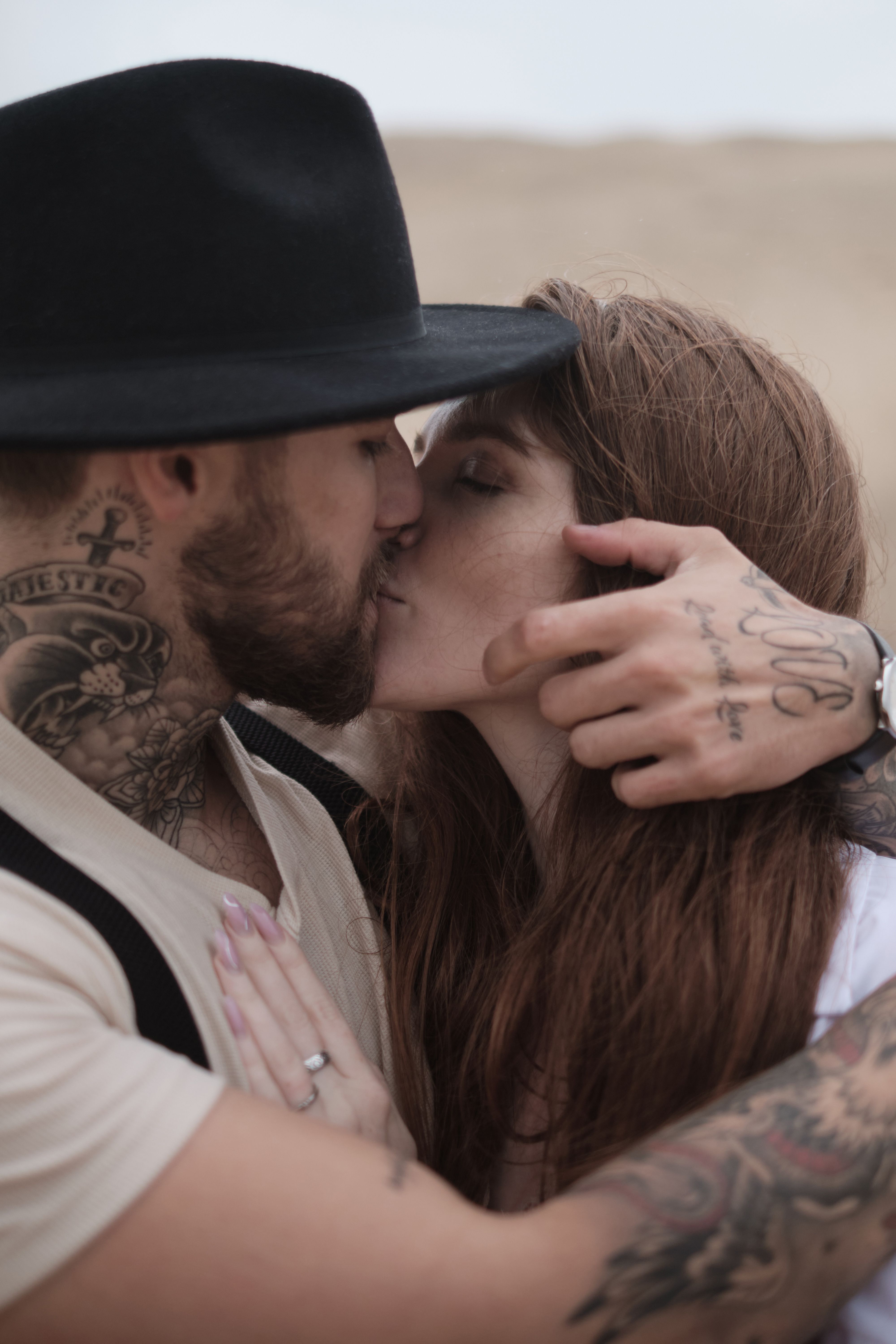 Tattooed couple sharing an intimate moment, outdoors.