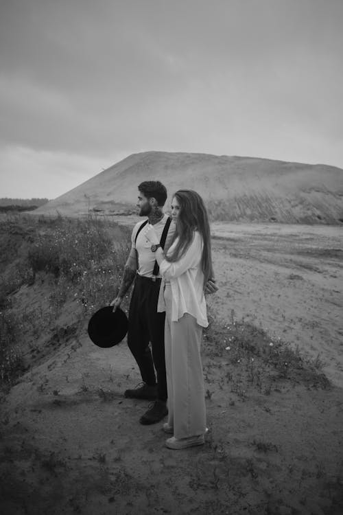 A man and woman standing in the desert